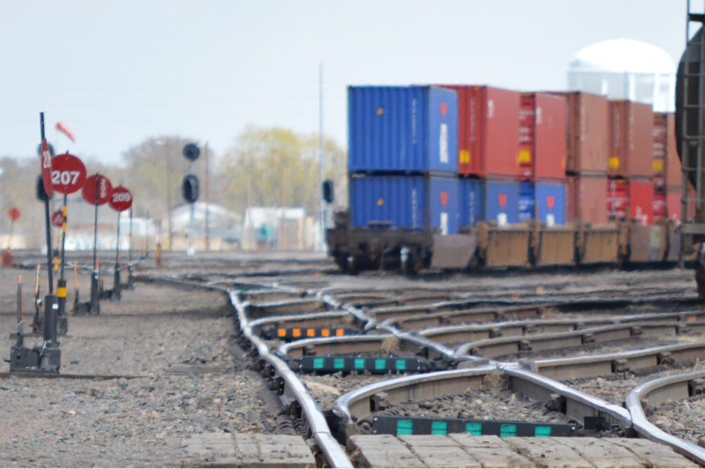 A train yard with several trains on the tracks.