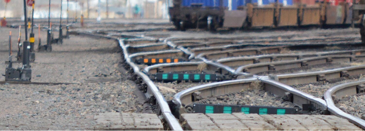 A train yard with several trains on the tracks.